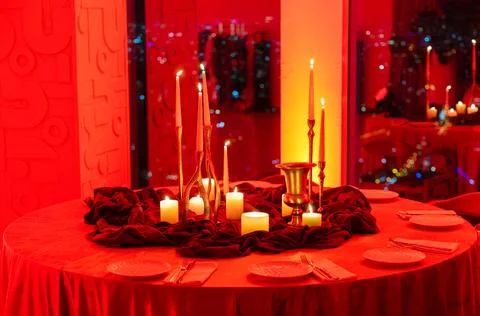 Romantic Candlelit Dinner Table with Red Lighting Stock Photos