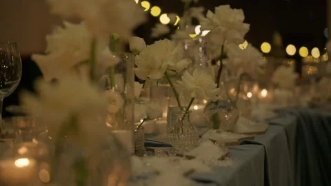 Romantic candlelit dinner table with white flowers Stock Footage 306330086