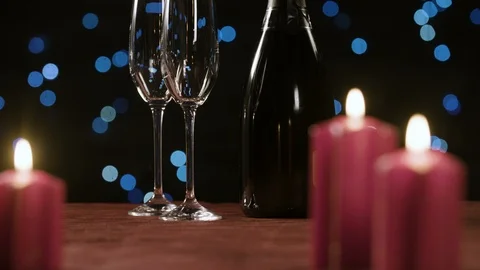 Romantic candles on a table with two glasses and bottle of champagne 스톡 동영상 98691125