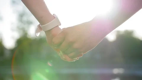 Romantic closeup of a young man`s hand holding a young woman`s hand when the Stock Footage 116686644