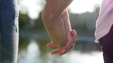 Romantic closeup of a young man`s hand holding a young woman`s hand when the Stock Footage 116686672