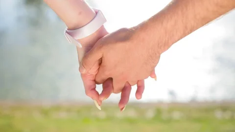 Romantic closeup of a young man`s hand holding a young woman`s hand when the Stock Footage 116687231