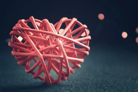 Romantic composition - one wicker heart a symbol of love on a dark table. Val Stock Photos