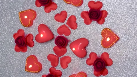 Romantic composition on a silvery surface with many hearts and burning candles Stock Footage 168675745