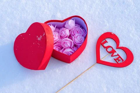 Romantic composition on the snow with a gift and a message Stock Photos