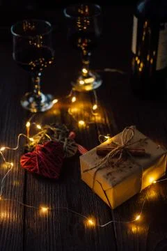 Romantic Composition of two hearts, box gift, lights and two glass of wine. Stock Photos