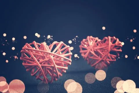 Romantic composition - two wicker hearts symbol of love and lights on a dark  Stock Photos