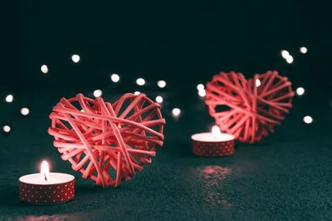 Romantic composition - two wicker hearts symbol of love, lights and a burning Stock Photos