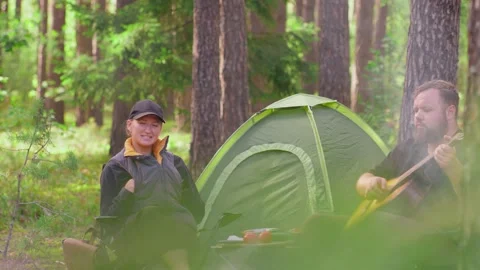 Romantic couple camping and playing guitar in the forest Stock Footage 323606710