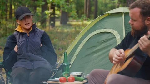 Romantic couple camping and playing guitar together 库存影片 327136699