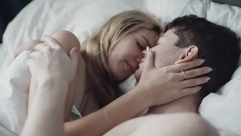 Romantic couple doing foreplay while lying in bedroom. Nude man and woman in bra Stock Footage 144243881