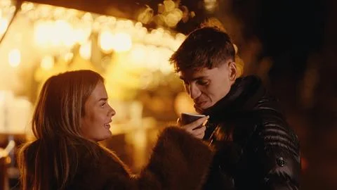 Romantic Couple Drinking Coffee At Paris Christmas Market With Bokeh Lights Stock-Fotos