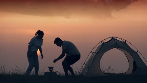 The romantic couple drinking hot drinks at the campsite Stock Footage 159685574