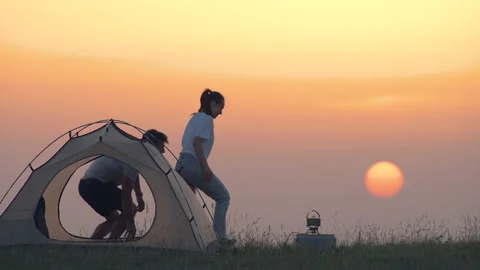 The romantic couple drinking hot drinks at the campsite Stock Footage 159686030