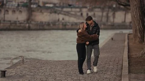 Romantic Couple Embracing On Cobblestone Path In Paris France With River Sein Stock-Fotos