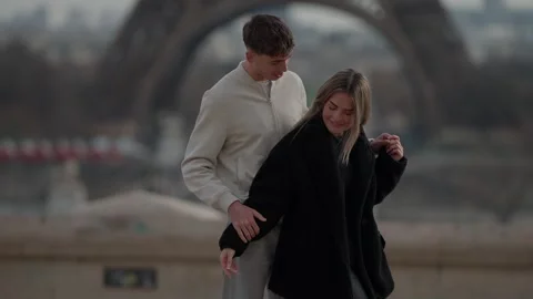 Romantic couple embracing with Eiffel Tower backdrop in Paris France Young Stock Footage 325235284