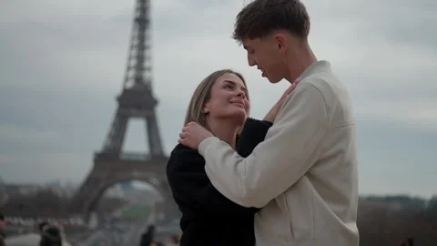 Romantic couple embracing with Eiffel Tower in background Paris France Young Stock Footage 325244569