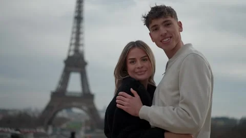 Romantic couple embracing with Eiffel Tower backdrop in Paris France Young Stock Footage 325275908