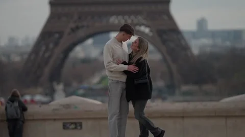 Romantic couple embracing with Eiffel Tower backdrop in Paris France Young Stock Footage 328568686