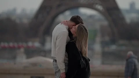 Romantic couple embracing with Eiffel Tower in background Paris France Young Stock Footage 328568997