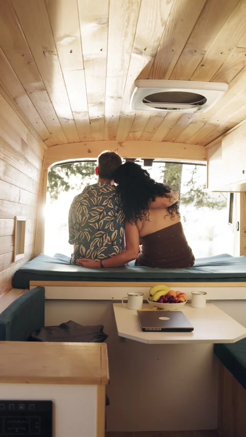 Romantic couple embracing inside a modern camper van. Vertical Stock Footage 344824447