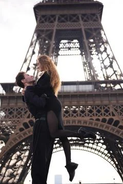 Romantic couple embracing under the Eiffel Tower in Paris Fotos Stock