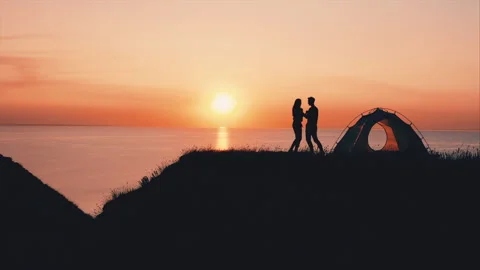 The romantic couple have fun on the mountain top against the beautiful sunset Video stock 156641926