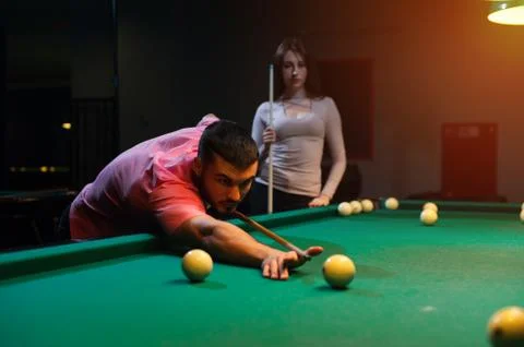 Romantic couple having fun playing billiard game Stock Photos