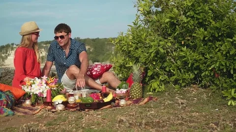 Romantic couple having picnic on the edge of Bali shore cliff Video stock 77954881