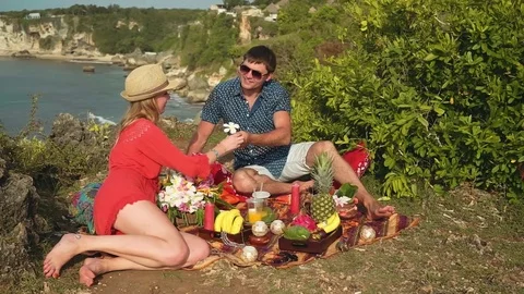 Romantic couple having picnic on the edge of Bali shore cliff Stock Footage 77954967