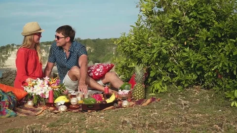 Romantic couple having picnic on the edge of Bali shore cliff Video stock 77955019