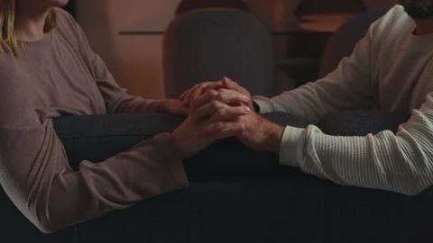 Romantic couple holding hands and caressing each other, sitting on a sofa a.. Stock Footage 304077391