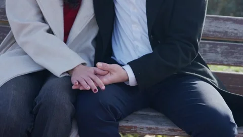 Romantic couple holding hands on a bench Stock Footage 325451784