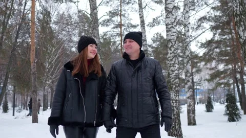 Romantic couple holding hands walking in snowy winter forest Stock Footage 330107944