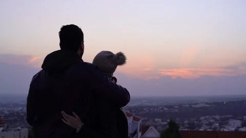 Romantic couple hugging and looking at sunset and city skyline Stock Footage 133280870