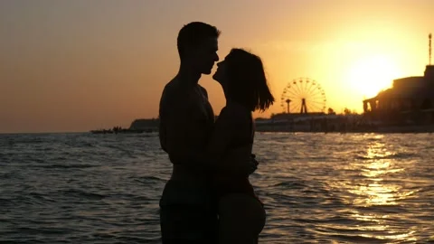 Romantic couple hugging, kissing each other in river waters at sunset in slo-mo Stock Footage