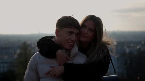Romantic couple hugging with Paris skyline in background Young lovers embrace Stock Footage 325264019