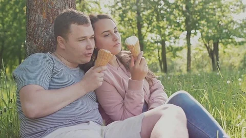 Romantic couple with ice cream at amusement park. Stock Footage