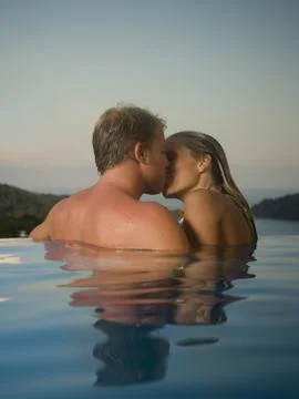 Romantic couple in infinity pool Stock Photos