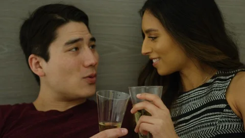 Romantic couple interacting with each other while having champagne in bedroom Stock Footage 111969040