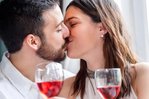 Romantic couple kissing at dinner. Stock Photos