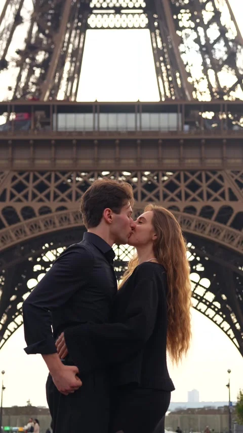 Romantic couple kissing under Eiffel Tower in Paris Stock Footage 314040960