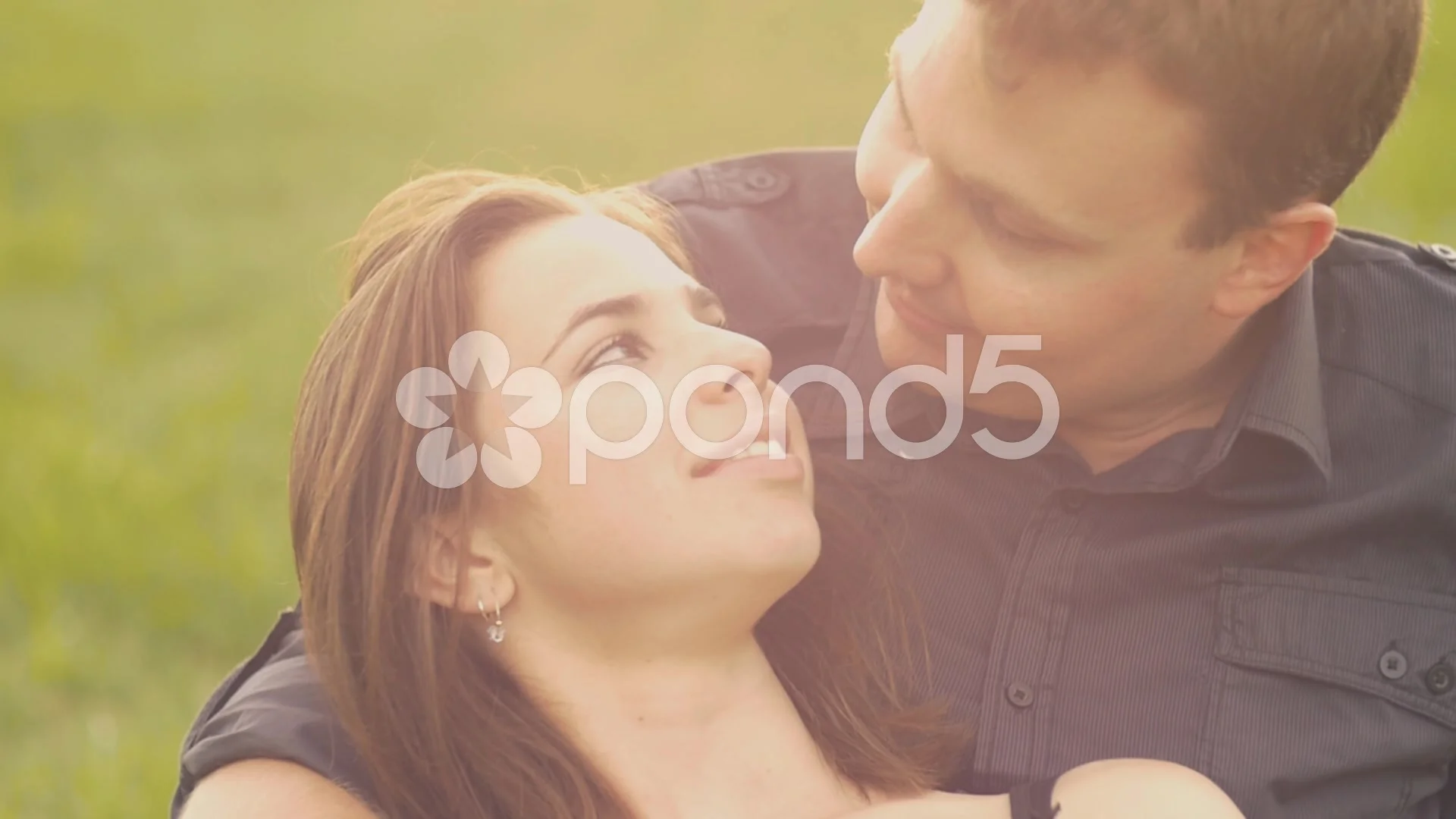 Romantic couple in love cuddling in a park sunset