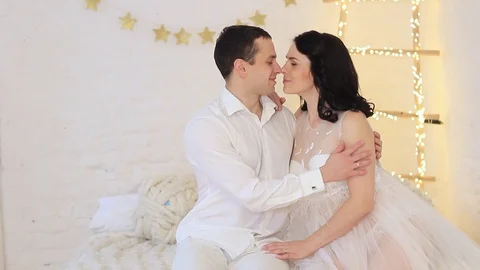 Romantic couple in photo studio on a sofa in white clothes Stock Footage 100604269