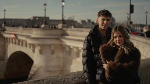 Romantic Couple Posing By Seine River On Pont Neuf Bridge In Paris France For Stock Photos