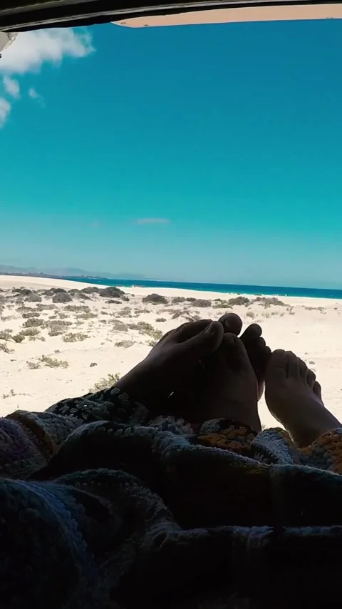 Romantic couple relaxing in a camper van, their bare feet up on a blanket Stock Footage 344847595