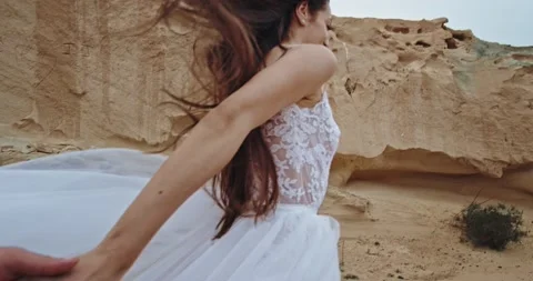 Romantic couple running through the rocks and cliffs in the middle of the nature Stock Footage 135232952