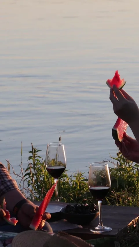 Romantic Couple Sharing Watermelon at Sunset by Lake, Summer Love Scene Stock Footage 332307572