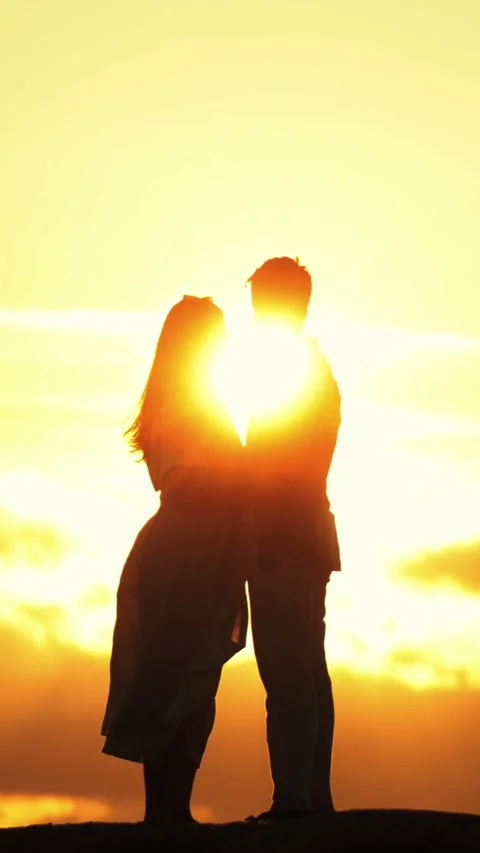 Romantic couple silhouette sharing a tender moment at sunset Stock Footage 328004027
