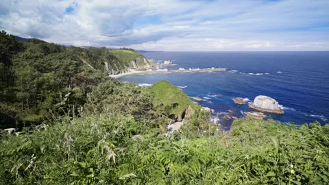 Romantic couple sitting on a bench overlooking the Asturias coast Видео 336492236